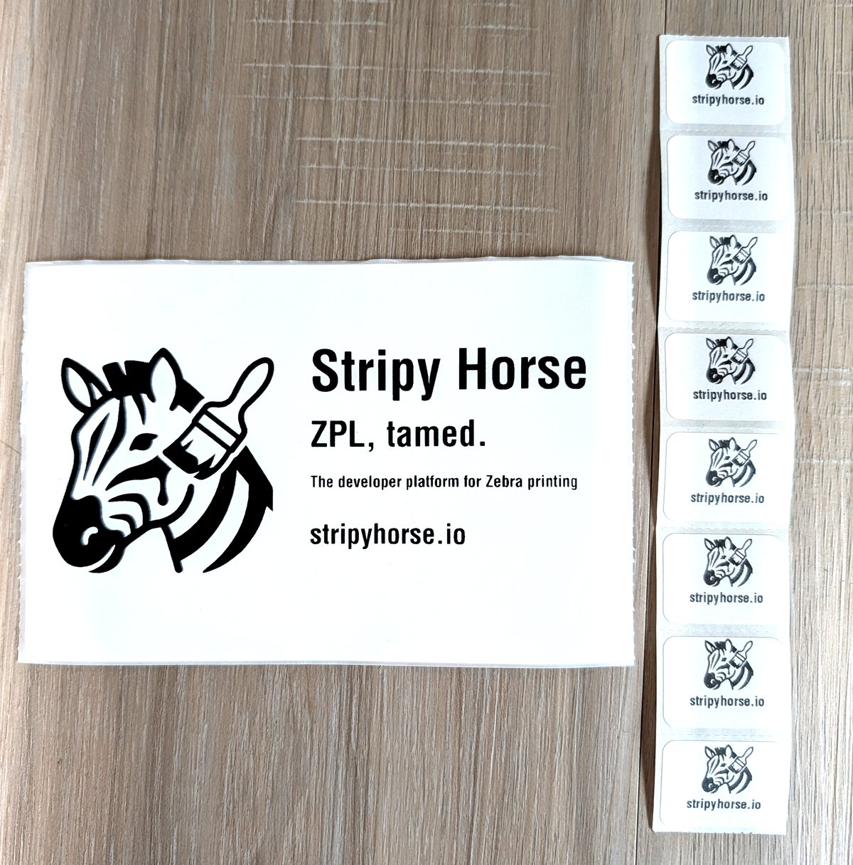 A Stripy Horse business-card label and a strip of small stripyhorse.io stickers, printed on a Zebra thermal printer